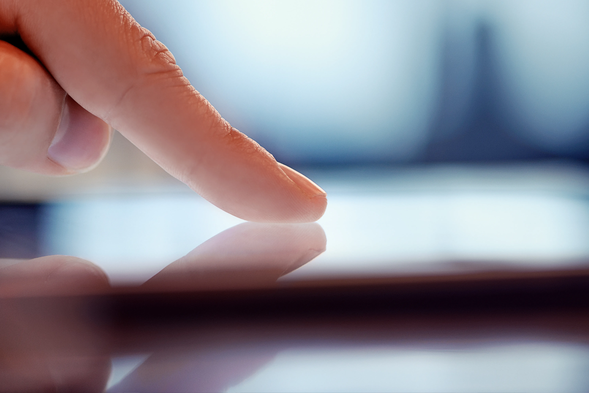 Nahaufnahme eines Fingers, der einen digitalen Bildschirm berührt.