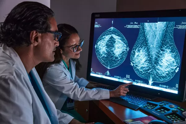 Radiologen bei der Durchsicht einer Tomosynthese-Mammografie auf einem Bildschirm