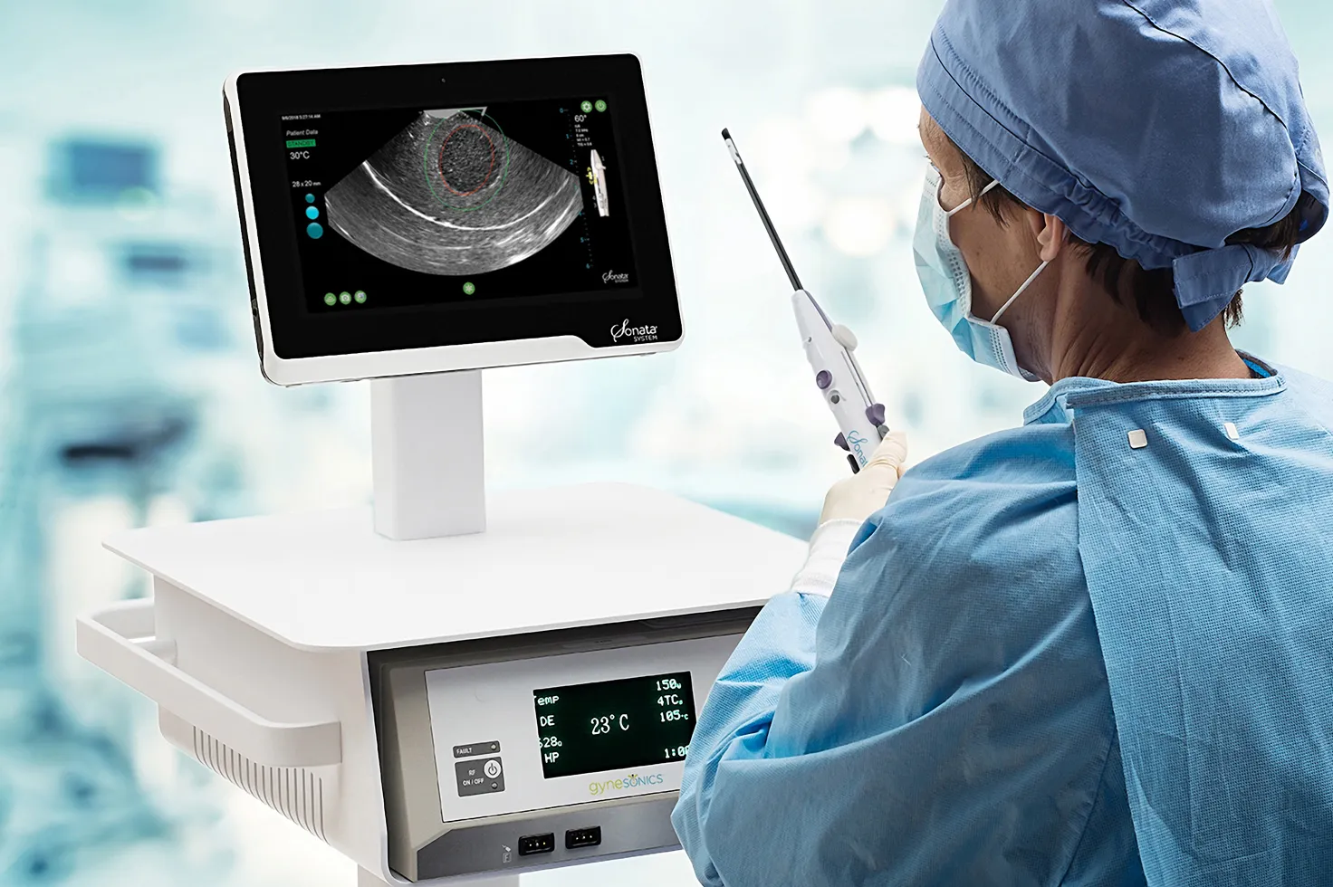 Person im OP mit Sonata-Handstück; Ultraschallbild auf dem Monitor.