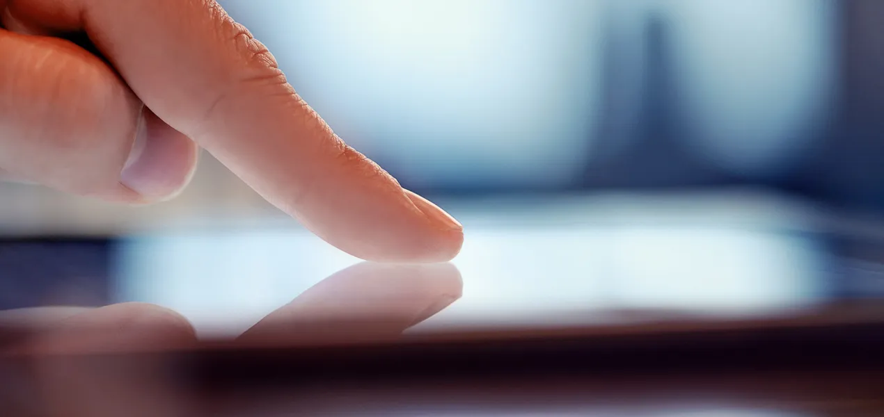 Nahaufnahme eines Fingers, der einen digitalen Bildschirm berührt