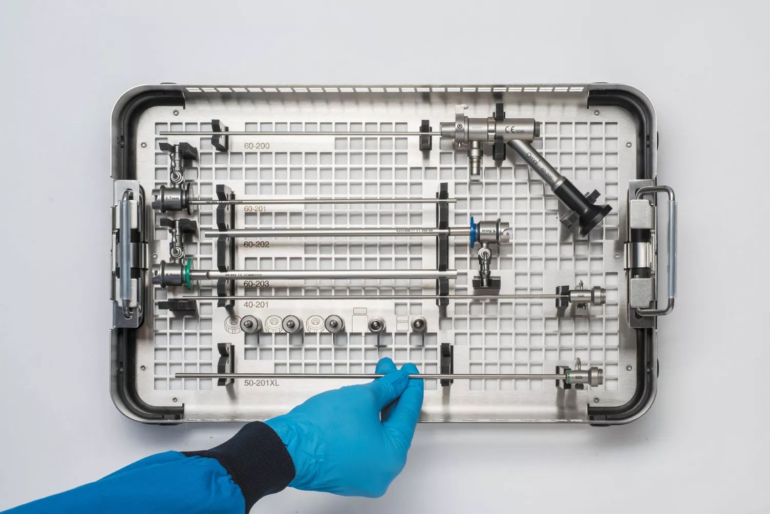 Behandschuhte Hand bei der Arbeit mit Instrumenten-Tray am Tisch.