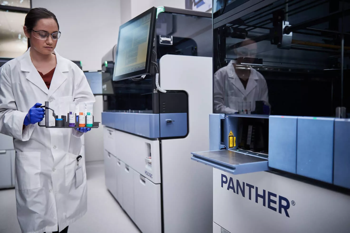 Labortechniker beim Tragen eines Fläschchen-Trays in Laborumgebung